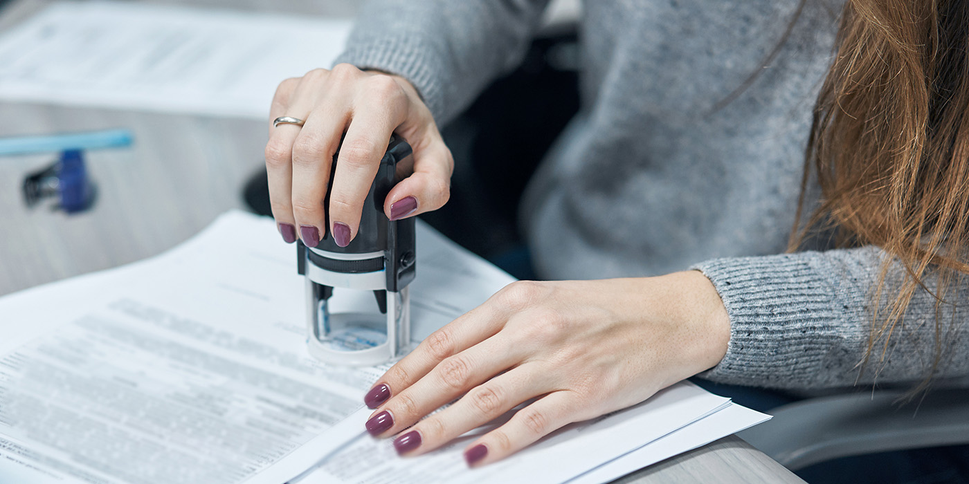 Person using a stamp on a document.