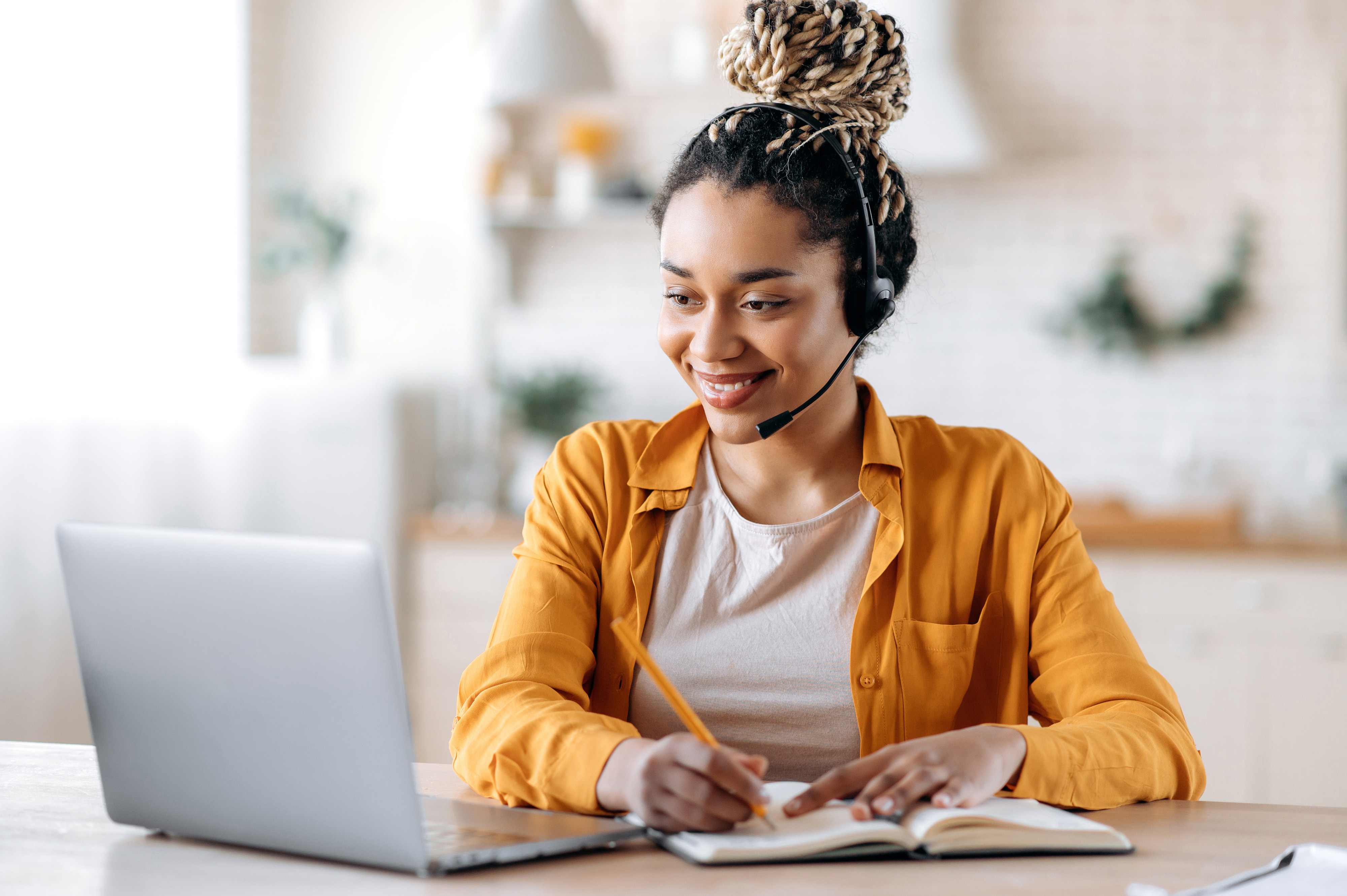 Woman with headset on typing at a keyboard.